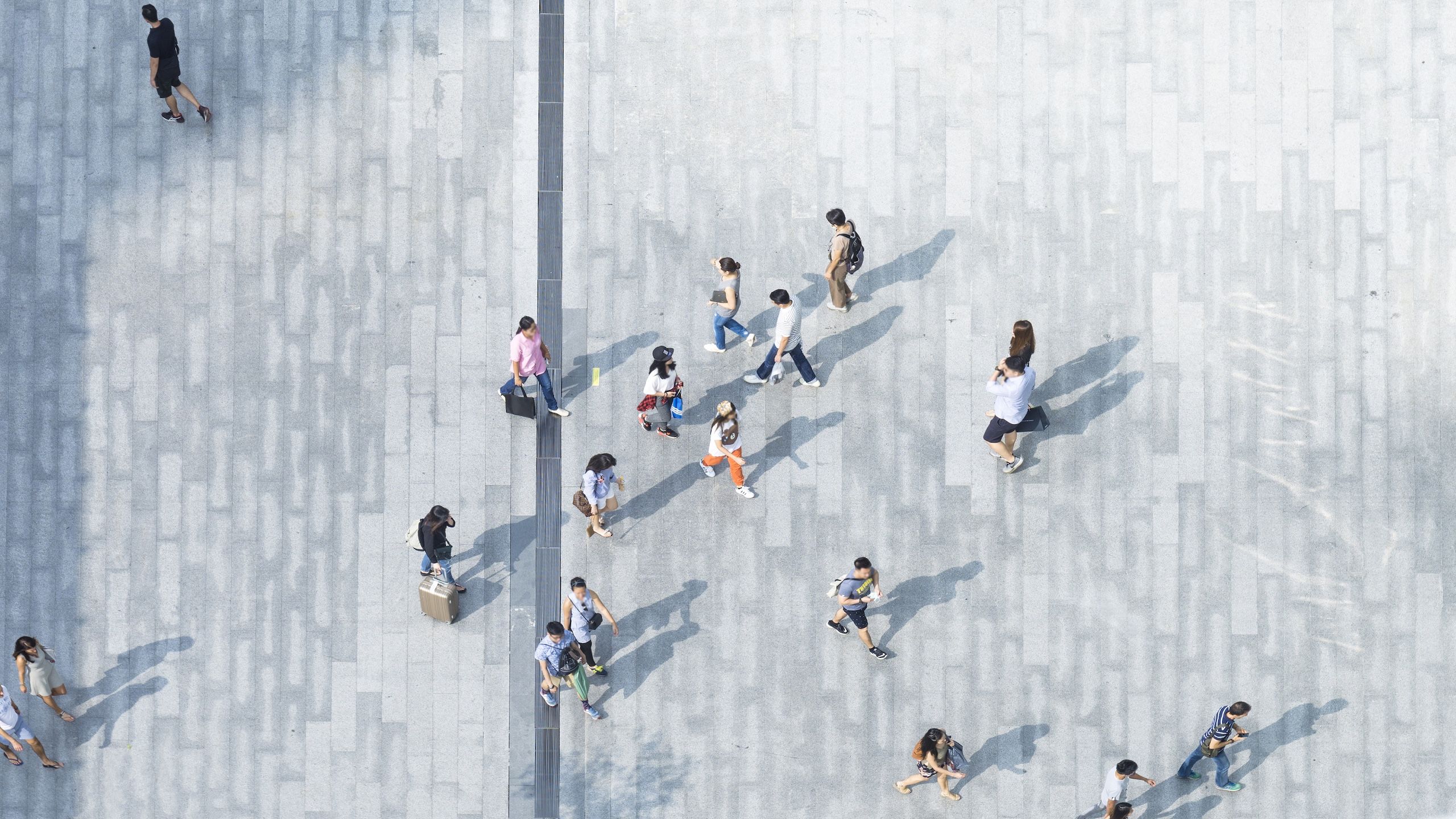 The image depicts a group of people on the sidewalk seen from above.